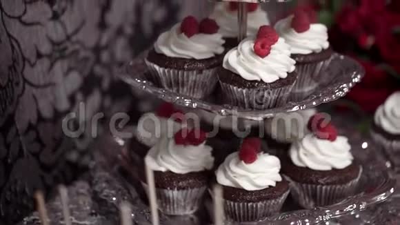 巧克力小蛋糕加鲜奶油和覆盆子放在糖果棒上视频的预览图