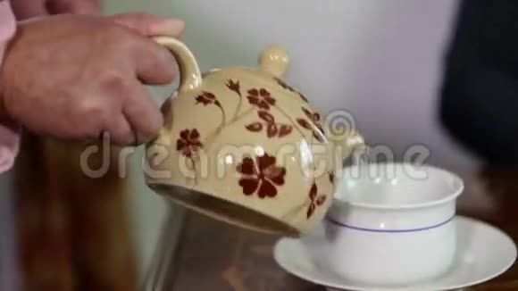 握着握手的老太太把茶倒进杯子里视频的预览图