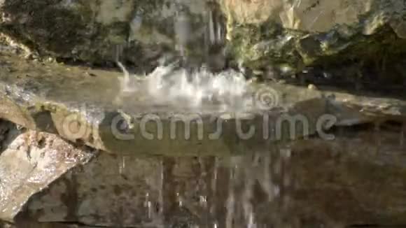 花园的石头瀑布水流过石头朝阳照瀑布视频的预览图
