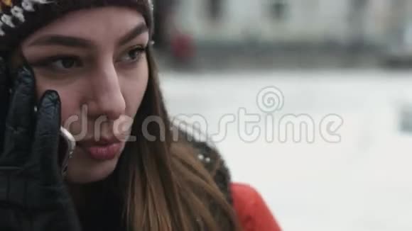冬天一个女孩在户外用手机聊天年轻女子在电话中交谈得很愉快视频的预览图