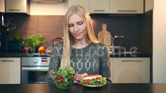 年轻女士喜欢沙拉而不是汉堡包有魅力的年轻女人坐着吃健康沙拉当午餐视频的预览图