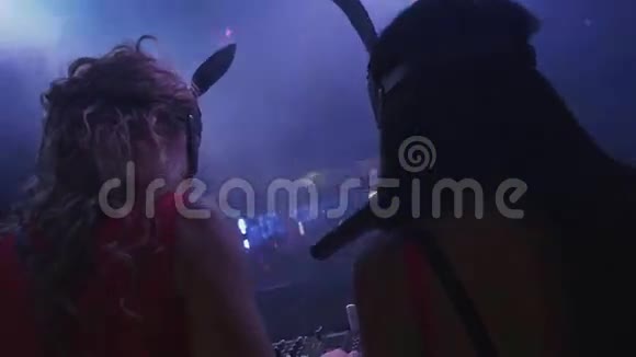 在夜总会的转盘上MC女孩和Dj女孩戴着兔子面具抽烟视频的预览图