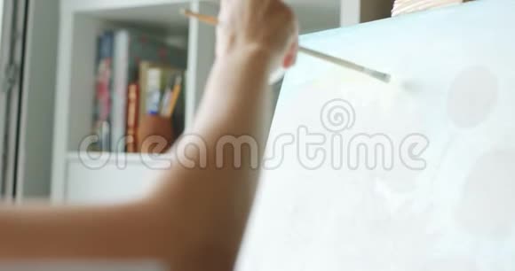 女艺术家在家庭工作室画画布视频的预览图