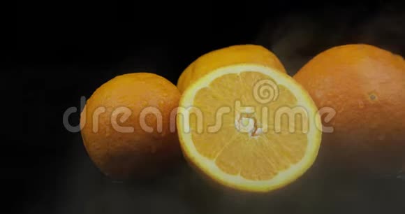 冷冰中的热带水果橙色黑色背景下的雾云视频的预览图