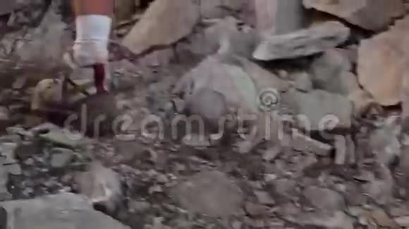 靠近徒步旅行者的脚在岩石山上行走视频的预览图
