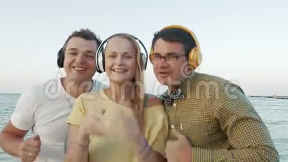 兴奋的三人在户外耳机中享受音乐视频的预览图