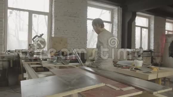 木匠用桌上的金属板量木板工艺制作家具视频的预览图