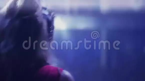 后侧DJ女孩穿红色连衣裙在夜总会转盘旋转跳舞视频的预览图