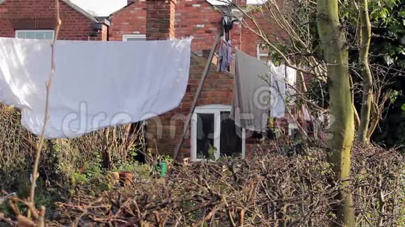 洗衣线袜子床单衣服和毛巾挂在维多利亚式的房子花园城镇城市生活视频的预览图