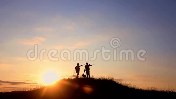 两个人站在山顶上的剪影背包和其他表达能量和幸福的齿轮视频的预览图