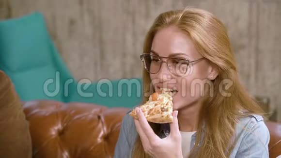 在咖啡馆里吃披萨的年轻女人视频的预览图
