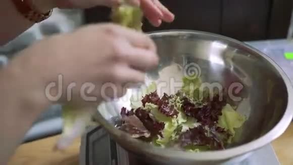 男人把生菜放进碗里放在厨房的秤上视频的预览图