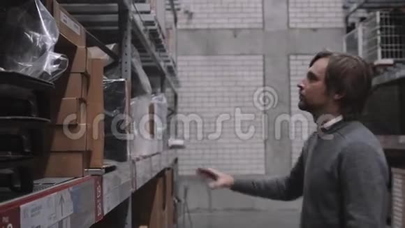 工人移动取出放置隔离从仓库的货架上提升带盒子的现代人视频的预览图
