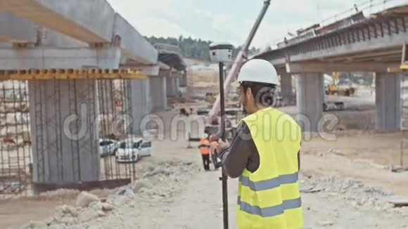 在大型建筑工地使用GPS测量装置的建筑工程师视频的预览图