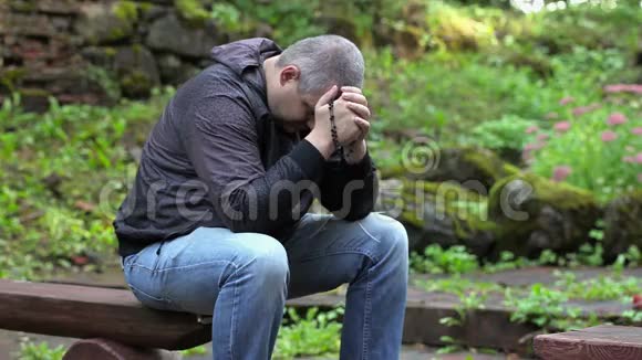 有人拿着念珠在长凳上祈祷视频的预览图