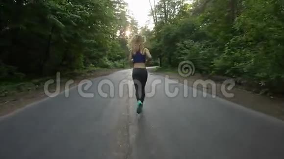 在森林里的路上奔跑的运动女孩户外健身用安定剂射击视频的预览图