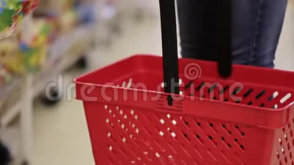 女人在超市把东西放在红色的购物篮里视频的预览图