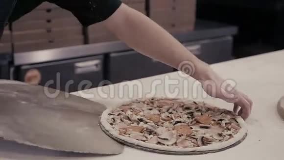 蓝色制服厨师面包师的特写手将比萨饼制作成烤箱供食物供应视频的预览图