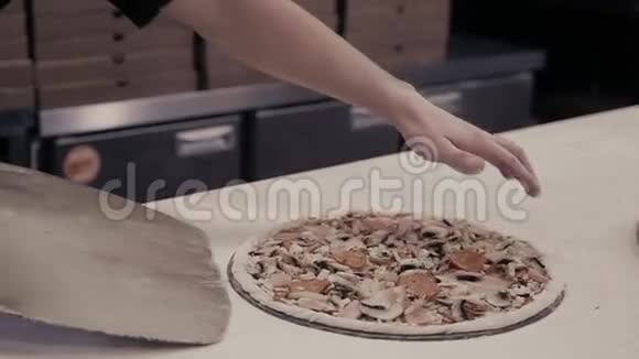 蓝色制服厨师面包师的特写手将比萨饼制作成烤箱供食物供应视频的预览图