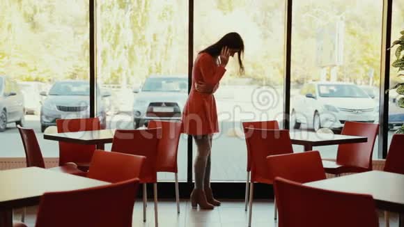 女人在咖啡馆的窗户附近打电话全面增长视频的预览图
