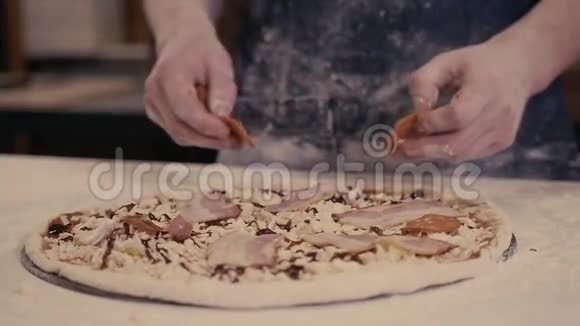 身着蓝色制服的厨师面包师特写镜头手在厨房制作披萨供现代餐厅送货视频的预览图