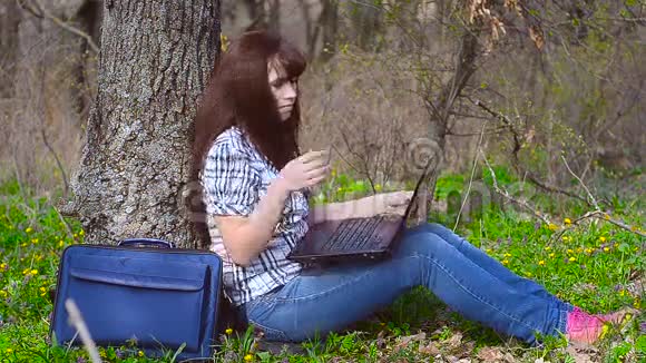 坐在笔记本电脑前用键盘打字的女孩视频的预览图