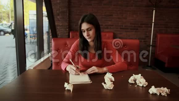 女人在创作过程中在笔记本上画画皱巴巴的视频的预览图