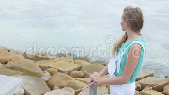 夏天穿着白色工作服的漂亮年轻女人站在木墩上视频的预览图