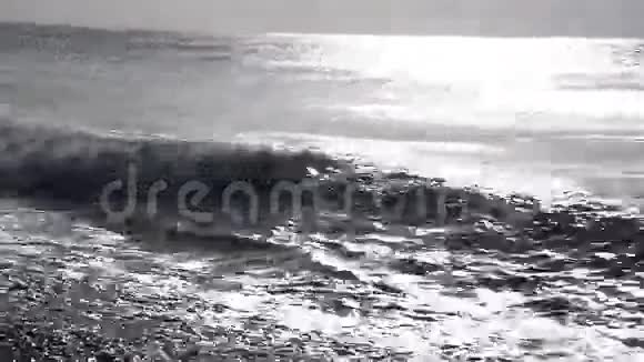 强烈的海浪在鹅卵石的海滩上大浪在夕阳的背景下视频的预览图