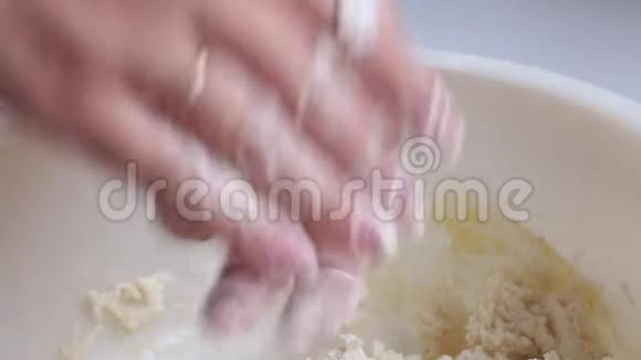 奶酪蛋糕的准备一个女人卷成面团容器里放着干酪一个鸡蛋被打掉了视频的预览图