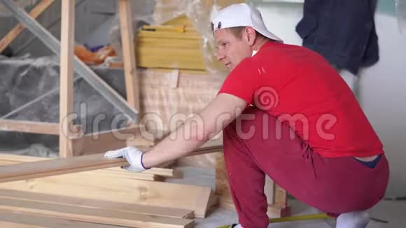 在房子里木工一个年轻的职业男性坐在松木地板上视频的预览图