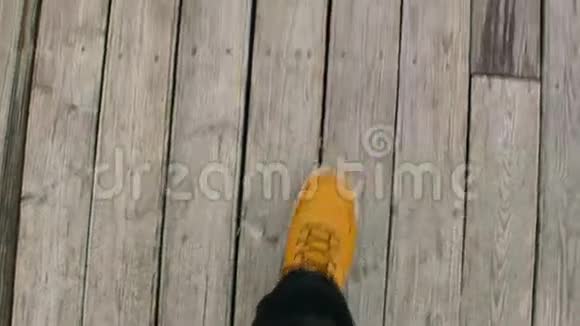 在海滩上的码头上POV射中了一个穿黄色鞋子的人视频的预览图