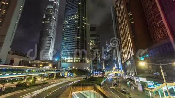 香港商业区夜间时间推移公司大楼在后面繁忙的交通穿过主干道视频的预览图