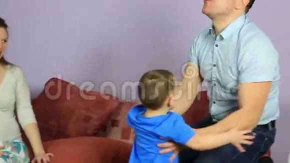 快乐的父亲举起他小儿子的手臂视频的预览图