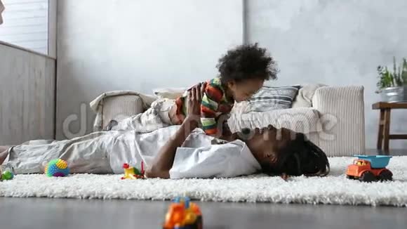父亲与躺在地毯上的蹒跚学步的儿子亲密接触视频的预览图