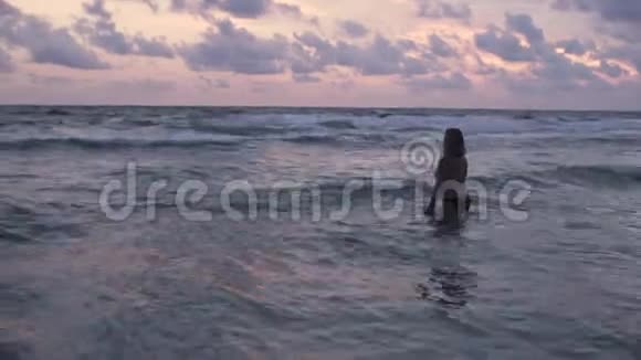 美丽的年轻孕妇在日落4k的水面上嬉戏视频的预览图