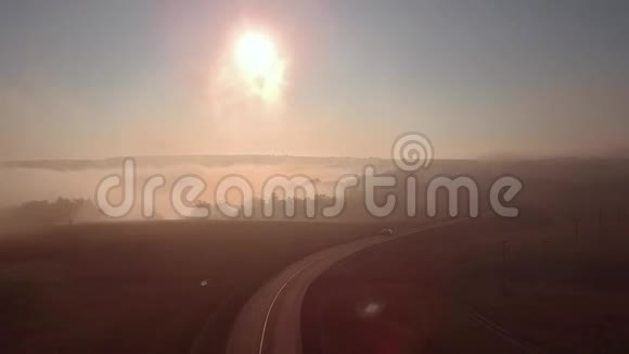 雾蒙蒙的日出和汽车轮廓的高速公路视频的预览图