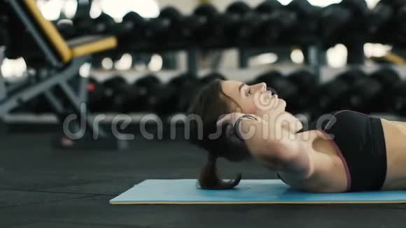 漂亮女孩在健身房锻炼做腹肌俯卧撑视频的预览图