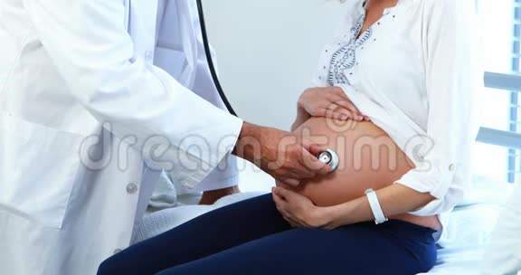 病房用听诊器检查孕妇腹部的医生视频的预览图