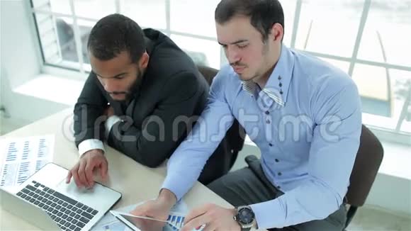 两个认真的商人在做平板电脑和一个视频的预览图