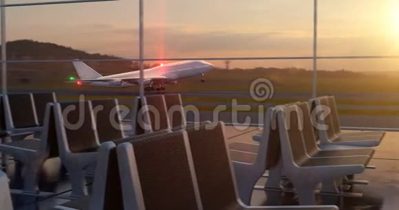 飞机在日落时分起飞从休息室的窗户看到视频的预览图