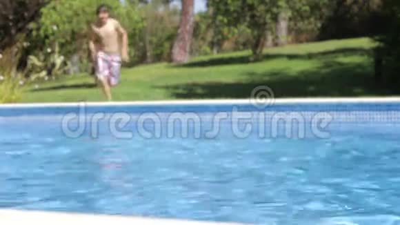 男孩跳入游泳池然后游过游泳池视频的预览图