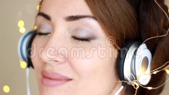戴着耳机的女人闭着眼睛听着音乐歌曲视频的预览图