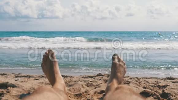 躺在海边的沙滩上的男人的腿视频的预览图