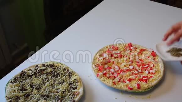 准备披萨那人用蟹棒撒牛披萨桌子旁边是一个披萨准备做饭和其他视频的预览图