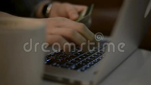 网上购物概念女人手拿着信用卡用笔记本电脑视频的预览图