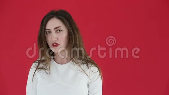 在红色背景下被孤立的不幸悲伤的女人视频的预览图
