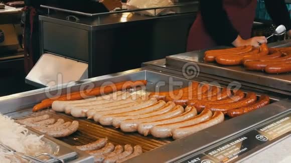 一位女售货员在烤架上烤香肠布拉格市中心的街头食品还有各种不同的香肠视频的预览图