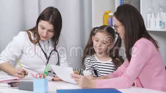 一个女人带着一个年轻的女儿在办公室和一位儿科医生交谈视频的预览图