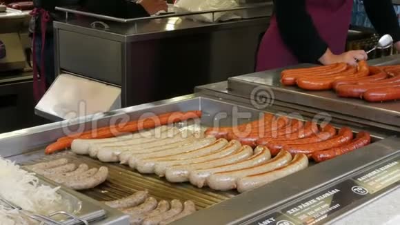 一位女售货员在烤架上烤香肠布拉格市中心的街头食品还有各种不同的香肠视频的预览图